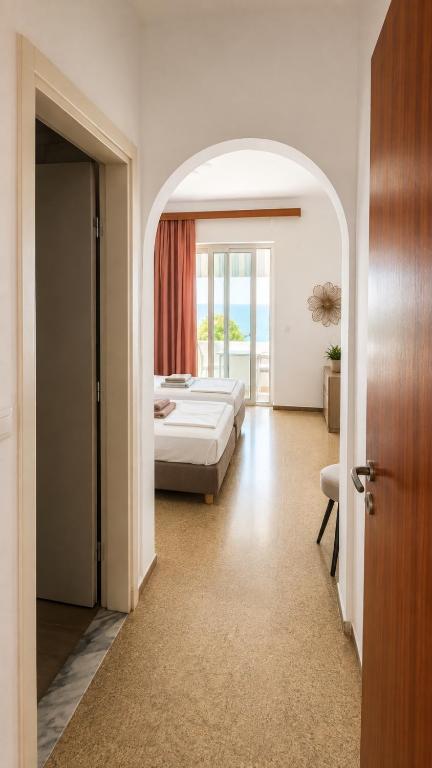Blick durch einen Rundbogen ins Schlafzimmer und durch die Balkontür zum Meer