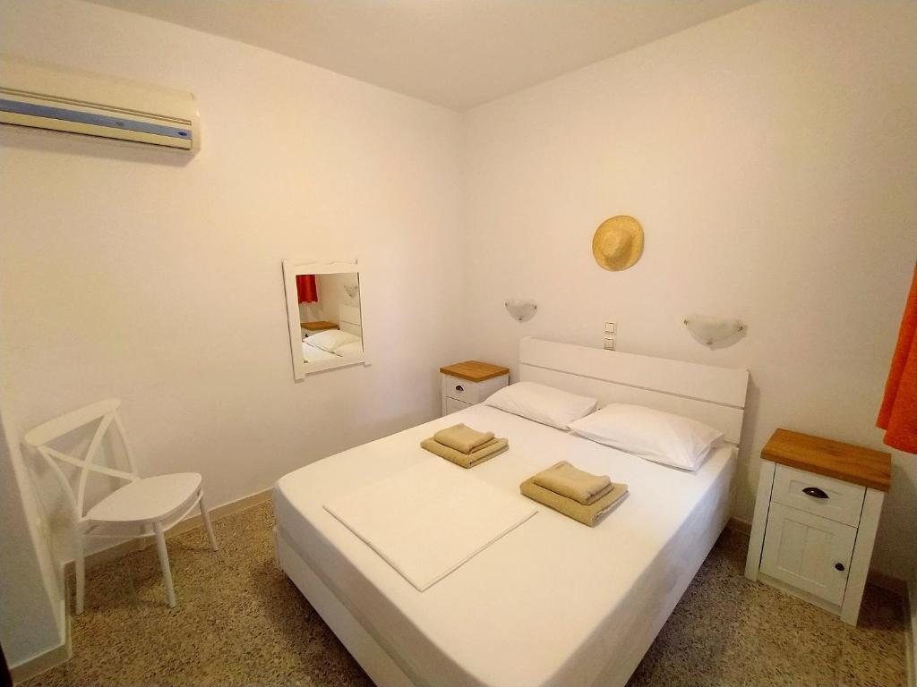 Schlafzimmer mit weißen Betten, hölzernen Nachttischen und Klimaanlage