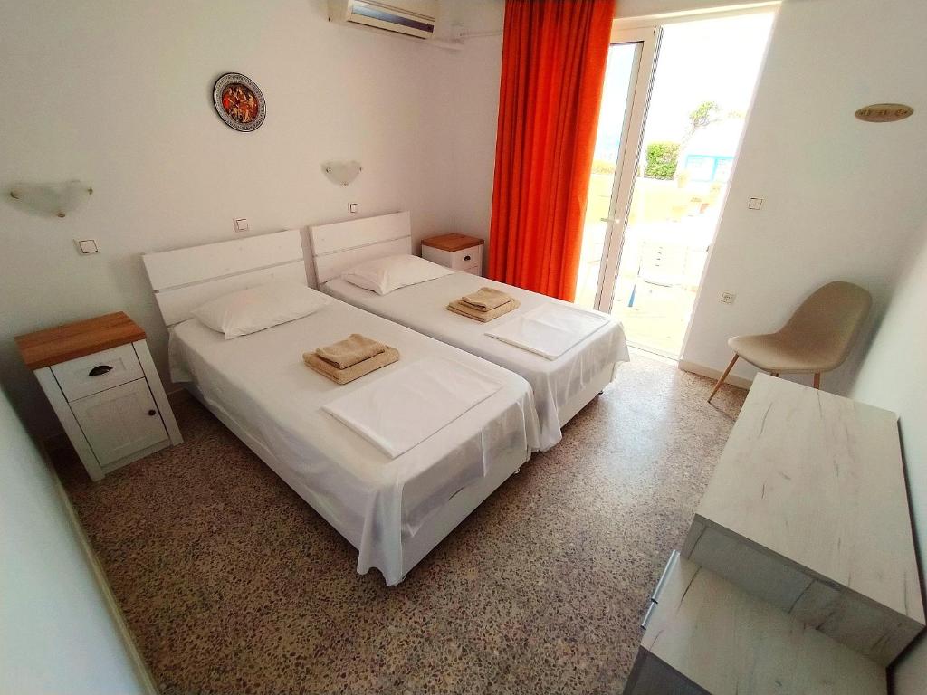 Helles Schlafzimmer mit zwei Betten, roten Vorhängen und offener Terrassentür