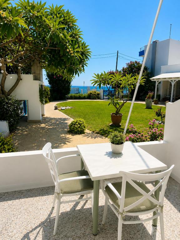 Terrasse mit heller Sitzgruppe und Gartenblick zum Meer